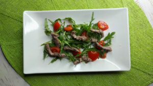 straccetti di vitello con rucola e pomodorini