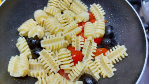 pasta con condimento di olive e pomodorini