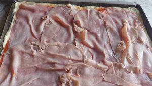 base pizza condita con prosciutto cotto