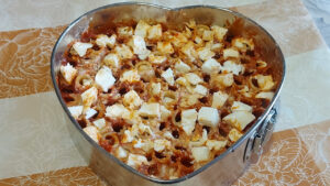 torta di pasta condita con sugo e mozzarella